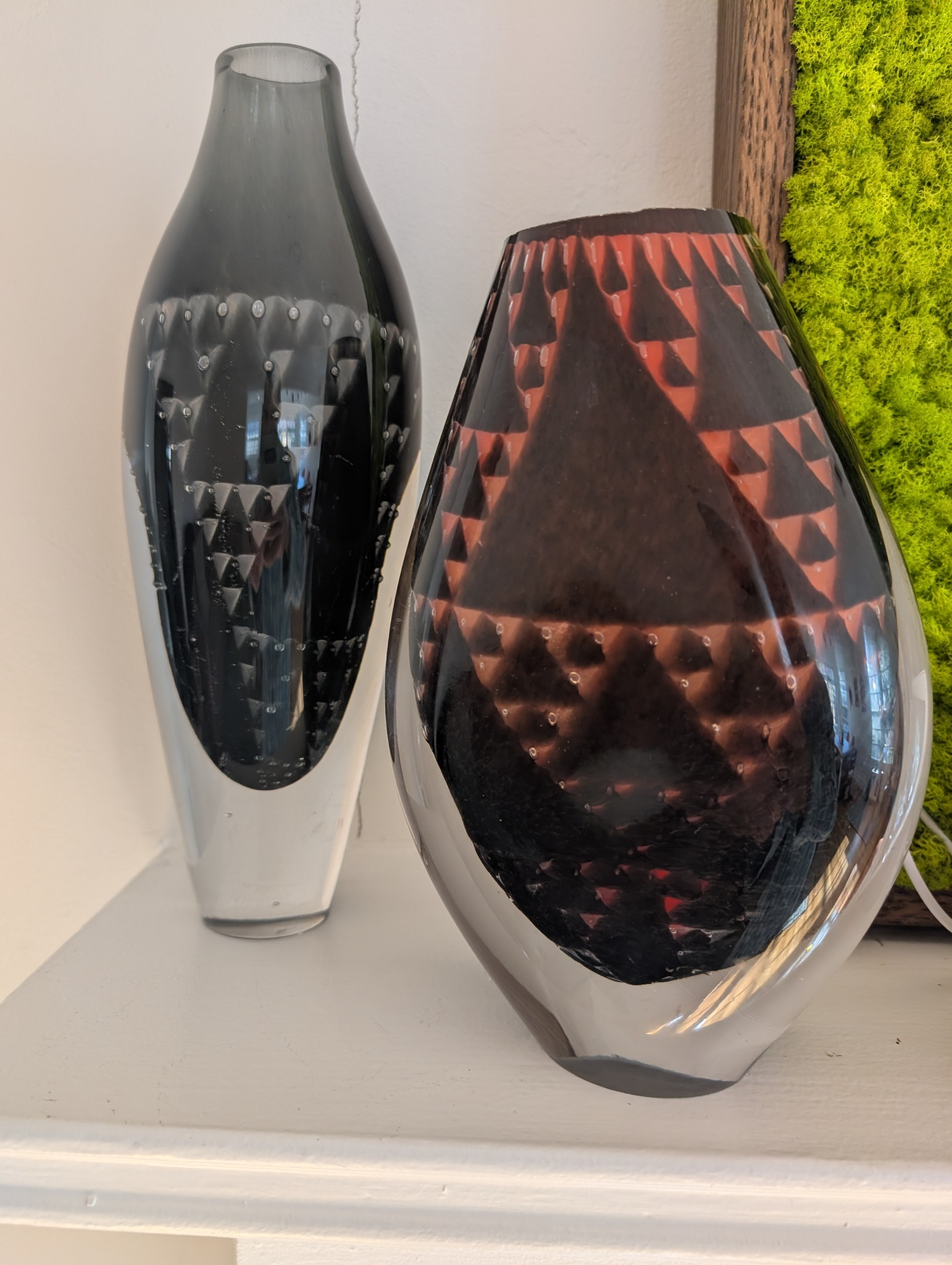 Two Pascaal’s Graal vessels on a white shelf showing layered red triangles